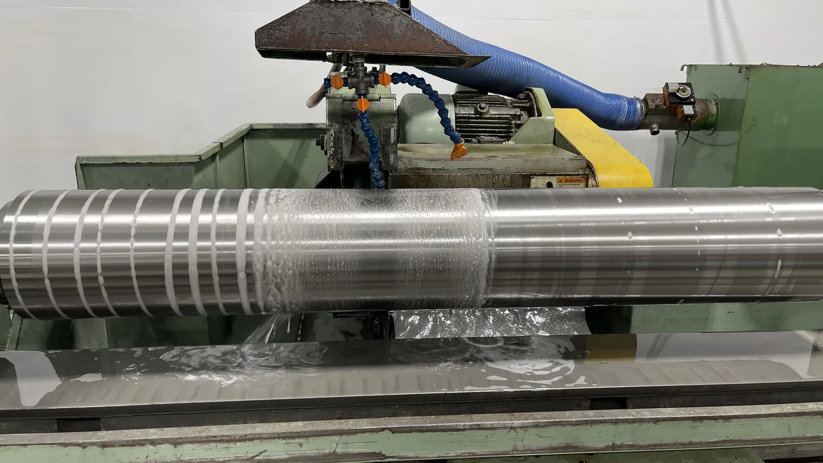 OD grinding a long roll on the cylindrical grinder with flood coolant